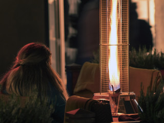 Heating street cafes, gas burner, the girl drinks tea