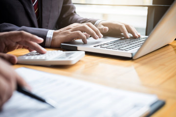 Fototapeta premium Co working conference, Business team meeting present, investor colleagues discussing new plan financial graph data on office table with laptop and calculator, Finance, accounting, investment
