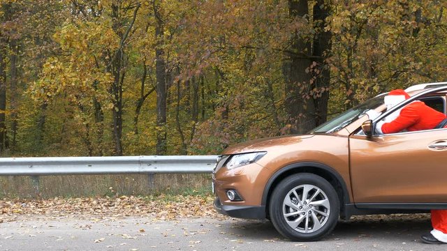 Santa Claus is pushing broken down car in the forest 50 fps