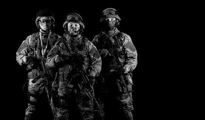 Three soldiers in uniform with a weapon in their hands are looking menacingly.