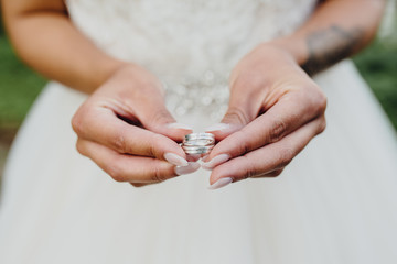 Braut hält Eheringe in den Händen