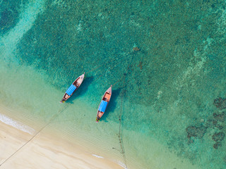Top view or aerial view of longtail boats on floating on emerald clear water along the sand beach in Phuket Thailand - obrazy, fototapety, plakaty