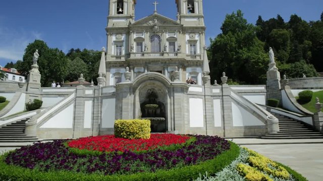 Tenoes near Braga. Sanctuary of Bom Jesus do Monte in neoclassical style and prospective view of bloom gardens in a sunny day, blue sky. Popular landmark and pilgrimage site in northern Portugal.