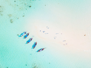 Top view or aerial view of longtail boats on crystal clear water along the sand beach in Phuket Thailand