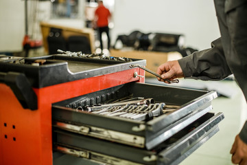 Man looking for tools in toolbox.