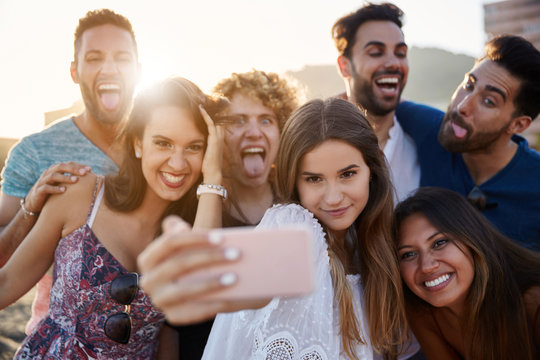 Group of friends taking selfie together having fun