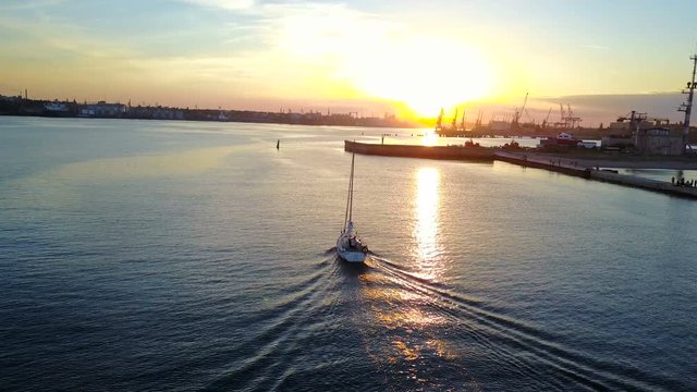 Yacht sailing in sea during sunset or sunrise. Sailing boat from drone