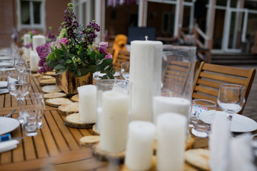 Dinner table served with candles and violet lilac