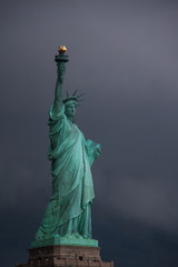Fototapeta premium Postcard from New York: Statue of Liberty against the stormy sky, Liberty Island