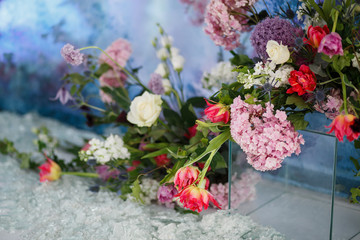 Glass box with long bouquet of pink, white and violet peonies, hydrangeas and roses