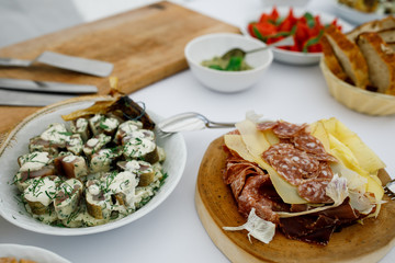 Fish with white souce and greenery and plate with sliced meat