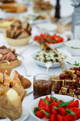 Plates with bread, vegetables, sliced meat and other snacks