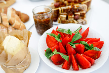 Plates with bread, vegetables, sliced meat and other snacks