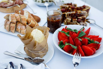 Plates with bread, vegetables, sliced meat and other snacks