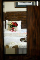 Bouquet of white roses, lilies and chrysanthemums lies on the bed
