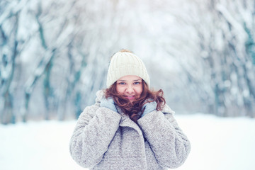 Fototapeta na wymiar portrait of beautiful girl enjoying winter weather in park