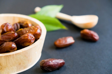 closeup sweet dried date palm fruits or kurma, ramadan (ramazan) food. Natural light. Selective focus. Close up on a black background. Top view, flat lay. copy space