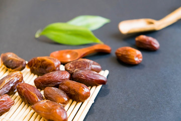closeup sweet dried date palm fruits or kurma, ramadan (ramazan) food. Natural light. Selective focus. Close up on a black background. Top view, flat lay. copy space