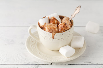 Mug of hot chocolate with marshmallows on table