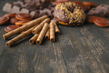 Chocolates background. Chocolate. Cup of hot chocolate, lemon, nuts and assortment of fine chocolates in dark, and milk chocolate on dark wooden table