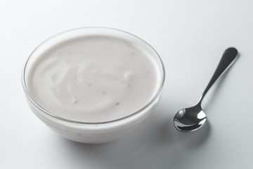 Yogurt in a glass plate on a white background.