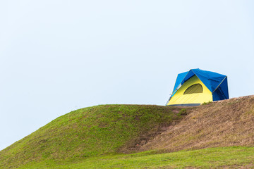 Single camping tent on the green hill