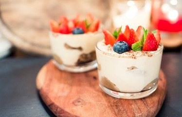 Summer dessert tiramisu, classic cheesecake with berries decorated with mint leaves.