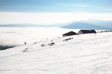 Fototapeta na wymiar Beautiful winter mountain landscape with clouds and ski slopes