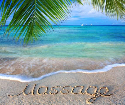 Massage concept written on sand.