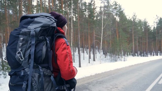 Woman hiking with a backpack in beautiful winter forest. Steadicam shot.