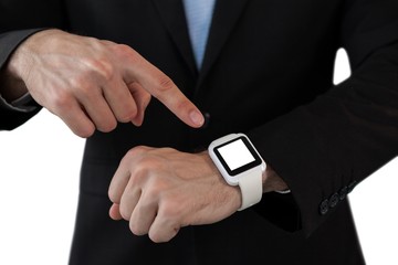 Mid section of businessman pointing on smart watch