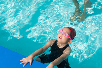 kid learn how to swim in swimming class