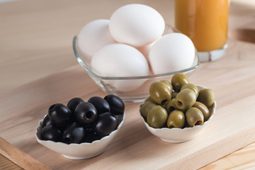 Olives, eggs, juice and other products on the table, healthy meals