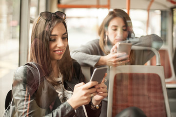 Young girl uses a mobile phone in the city bus
