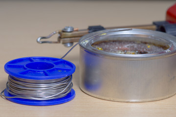 Przybory używane w lutowaniu przewodów. Lutownica, kalafonia i cyna. Zdjęcie z bliska.