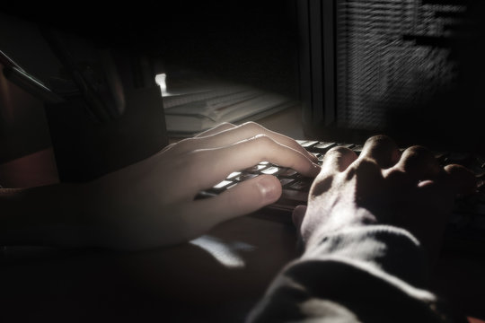 Programmer's hands on the keyboard, dark background