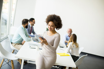 Smiling African woman using a tablet in office