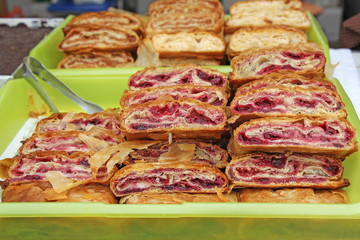 Sliced homemade strudel with cherry in streat market
