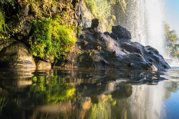 Mountain waterfall falls in a lake near a cliff