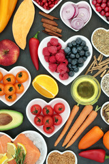 Super food for a healthy heart concept with fruit, vegetables, fish, herbs, spice, olive oil and fish on slate. High in omega 3, anthocyanins ,antioxidants, fibre and vitamins.