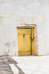 Yellow wooden door on Amorgos island, Cyclades of Greece.