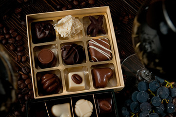 chocolate box full of Belgian pralines. Romantic dinner lovers and some wine and grapes