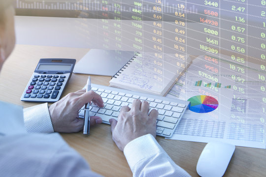 Businessman analysing investment risk on computer with spreadsheet screen graphic display in light opacity 