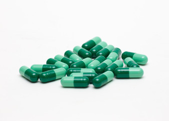 Green Pills Against White Backdrop