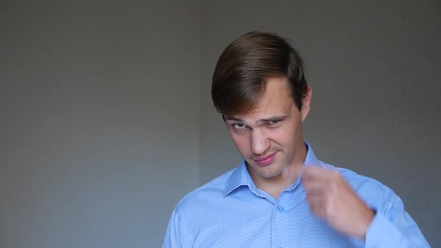 4k. Close up of man . portrait of a young man. body language and gestures. he twists her finger at her temple