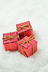 Rote Päckchen im Schnee / drei rote Päckchen im Schnee, Nahaufnahme, Hochformat
