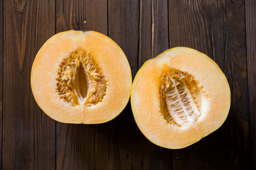 Melon cut in half on a wooden background (Top view)