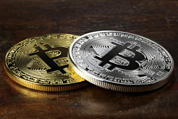 golden and silver bitcoins on wooden background