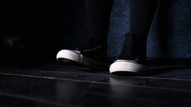 Girl in sneakers narulously and rhythmically stomping her foot