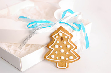 Ginger delicious gingerbread in the form of snowflakes and fir trees in a stylish gift box on a white background. Holiday gift
